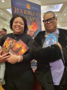 Two African American women holding Crimson Hunter, A Queen's Pride, and Mafdet's Claws by ND Jones